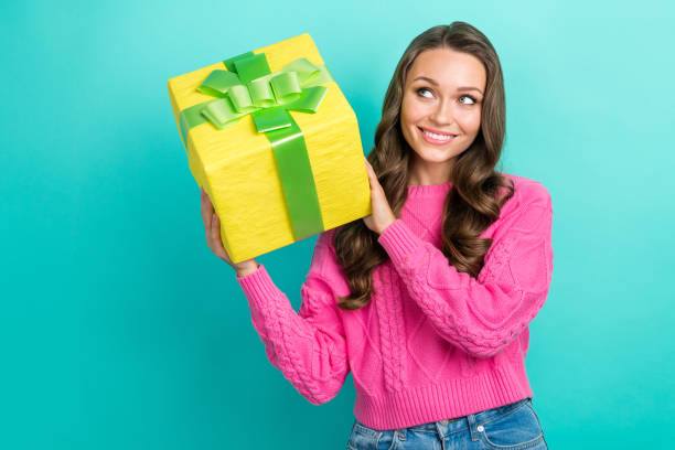 istock Photo of dreamy adorable lady dressed knitted pullover holding gift box looking empty space isolated teal color background 2165988937