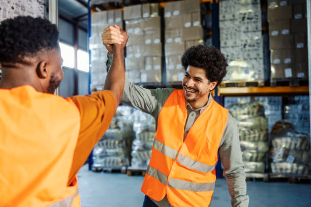 istock Diverse workers having bro handshake at warehouse. Teamwork at industry 2165990320