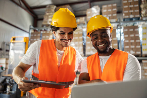 istock Smiling multicultural logistics coordinators tracking shipment on laptop at supply chain. 2165990678