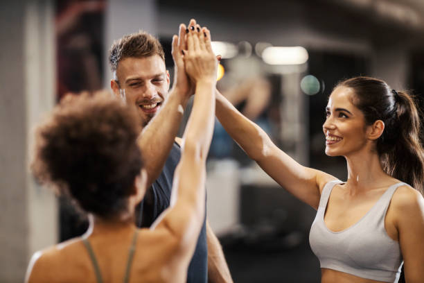 istock Sporty friends giving high five while standing in a gym. 2165990950