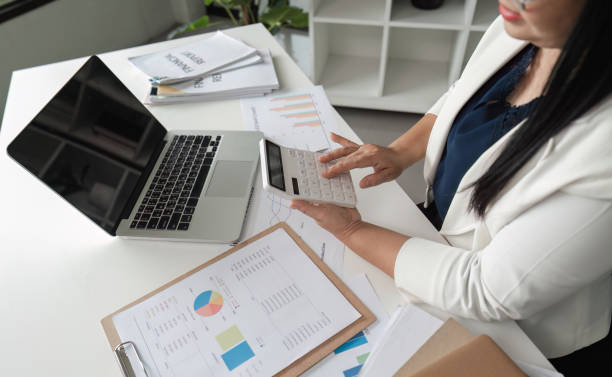 istock Middle-aged Business Woman Doing Paperwork and Working on Computer in Modern Office Setting 2166005456