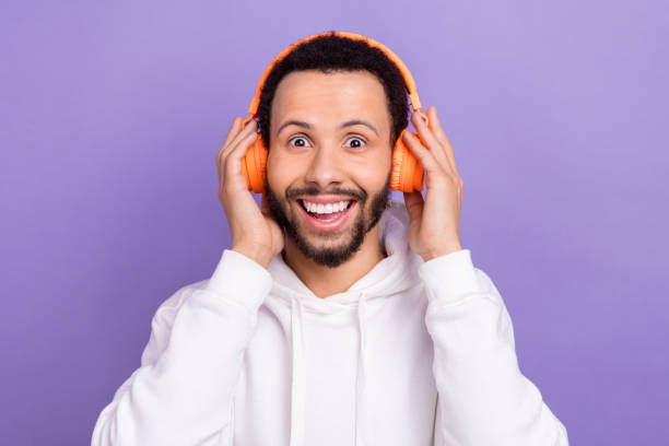 istock Portrait of impressed guy brunet beard white pullover touch headphones open mouth excited playlist isolated on violet color background 2166005559