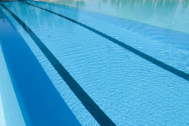 istock Swimming pool with blue water and sun reflections. Swimming pool background 2166009408
