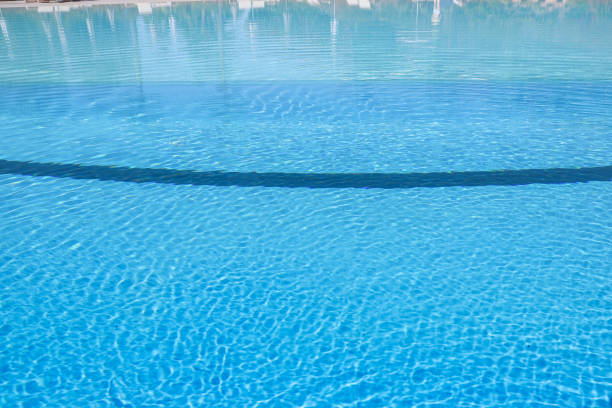 istock Swimming pool with blue water and sun reflections. Swimming pool background 2166009436