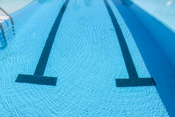 Swimming pool with blue water and sun reflections. Swimming pool background