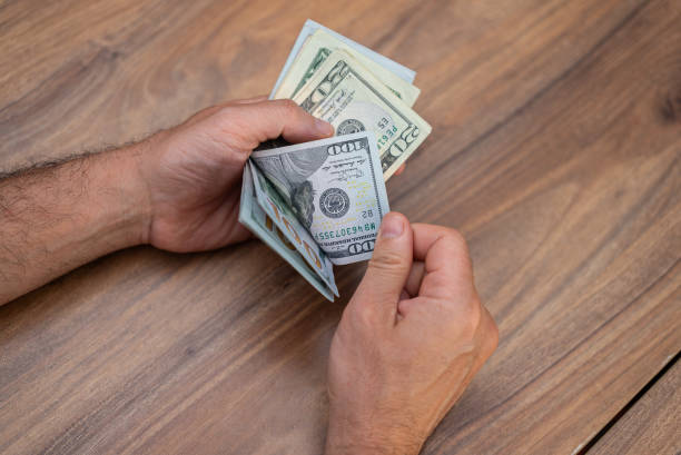 istock Male entrepreneur holds dollar banknotes in hands preparing necessary quantity for paying services 2166010920