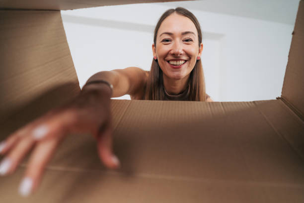 istock Smiling woman opening a carton box 2166019028
