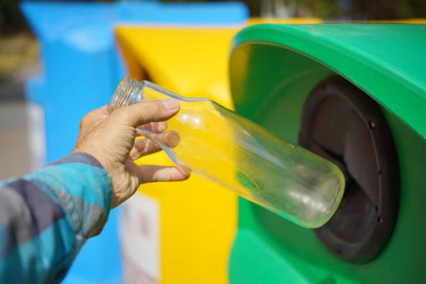 istock A Hand Placing  Glass Bottle Into a Recycling Bin 2166021031