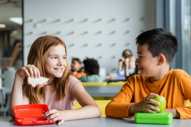 Joyful multicultural classroom with children enjoying lunch