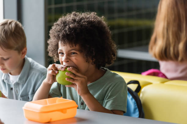 Multicultural school kids enjoying snacks during lunch break