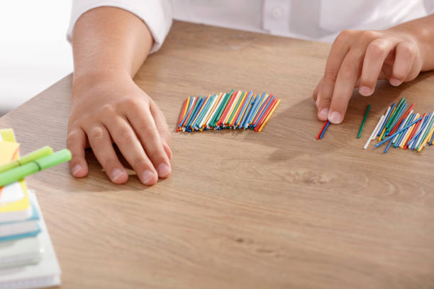 istock A pupil sitting at a classroom desk and counting sticks in a mathematics lesson. 2166027608