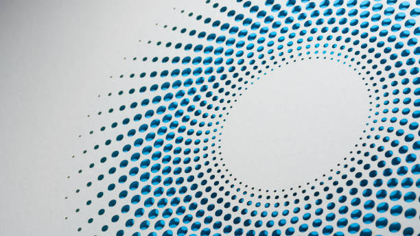 istock Circular pattern of perforated dots on white paper showcasing a gradient from dark to light blue shades. 2166030866
