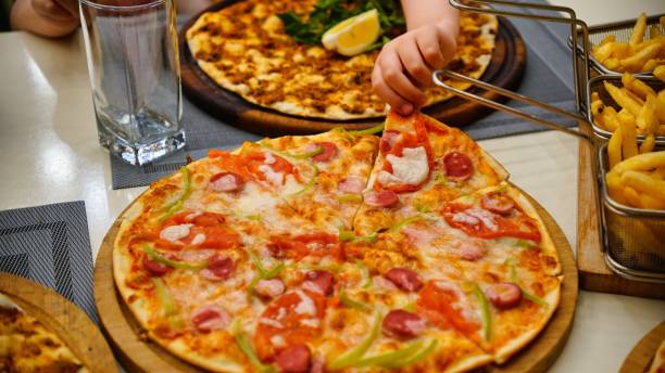 istock Hand Reaching for Pepperoni Pizza Slice 2166031264