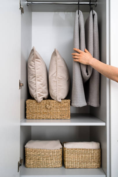 istock Linen closet in bedroom with pillows, blankets and wicker baskets 2166031606