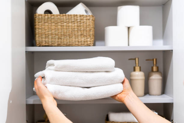 istock Person placing white towels on bathroom shelf 2166031609