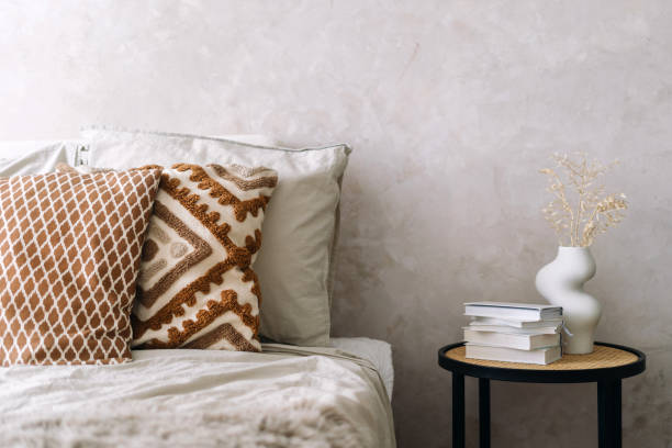 istock Side table, bed and home decor with books in bedroom 2166031694