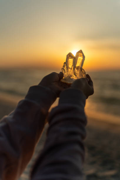 istock Holding magic healing crystals. Astral energy from the setting sun 2166031713