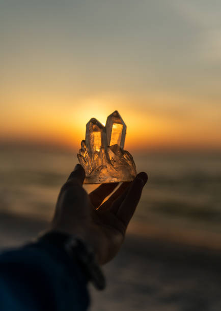 istock Holding magic healing crystals. Astral energy from the setting sun 2166031715