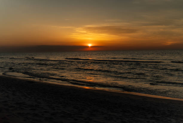 Scenic view of natural scenery. Golden sun setting at the sea's horizon