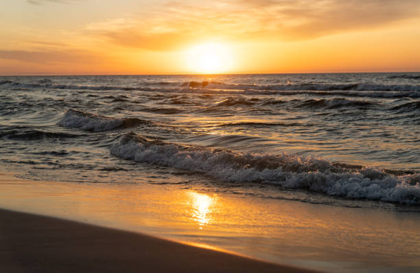 istock Bright golden setting sun illuminating the sea and the beach 2166031861