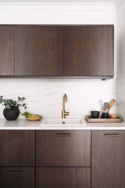 istock Faucet over sink built in marble countertop with local farm vegetables and kitchenware on kitchen table 2166032453
