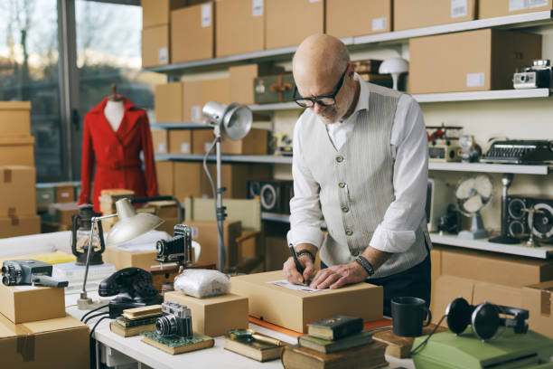 istock Seller writing the address on a delivery box 2166033476