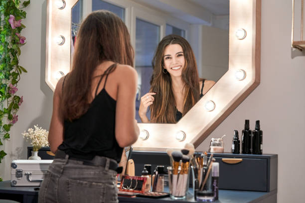 istock Cheerful woman making up at mirror 2166041571