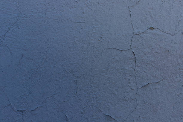 Cracked blue paint on the wall. Old peeling painted textured background.