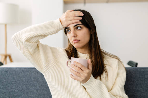 istock Beautiful young woman in sofa suffering bad headache 2166043437