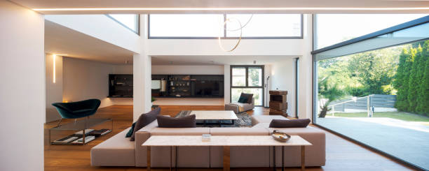 istock Modern living room with large sofa, with chaise longue, central coffee table, above a large carpet. Interior of a modern house on two levels 2166048080