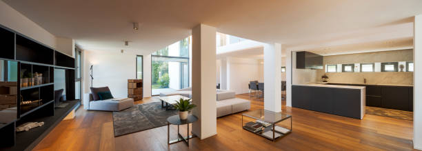 istock Modern living room with large sofa, pouf, central coffee table, above a large carpet. Interior of a modern house on two levels open space 2166048402