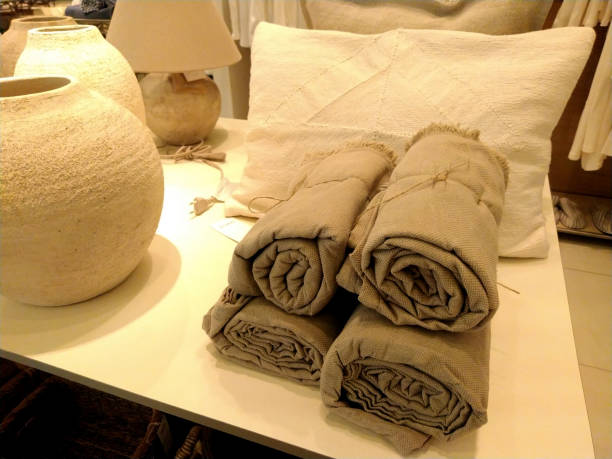 istock Cozy Home Decor Display with Rolled Neutral Blankets, Textured Pillows, and Rustic Ceramic Vases 2166050877