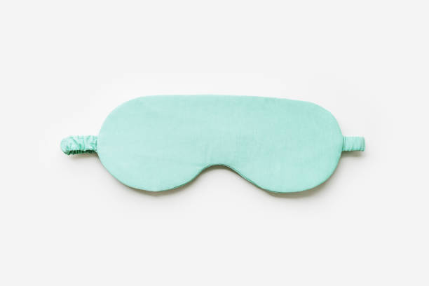 istock Sleeping mask for healthy quality sleep on white light background. One mint colored eye mask for best sleeps. Stylish silk eye cover or blindfold for travel, comfort rest, minimal top view 2166052658