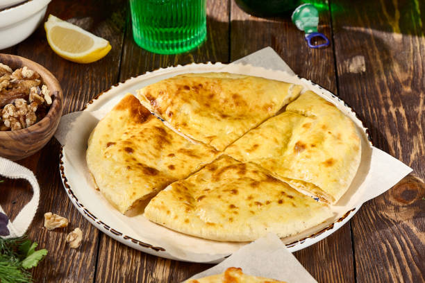 istock Traditional Ossetian Cheese Pie on Rustic Wooden Table with Garnishes 2166054191