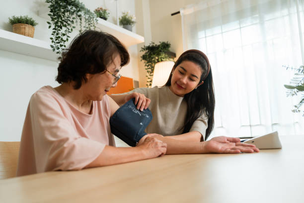 istock Caring Daughter Assists Elderly Mother with Blood Pressure Check 2166055152