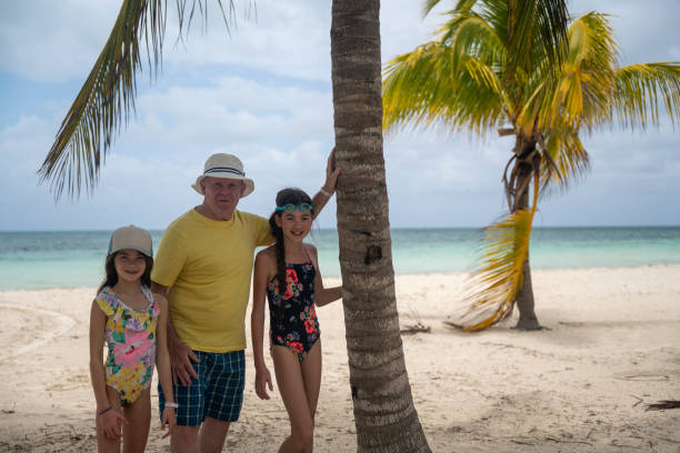 istock Grandfather with granddaughters relax on beach 2166057835