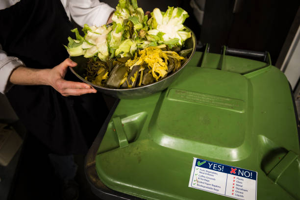 istock Woman server puts organic waste into bin for composting 2166059293