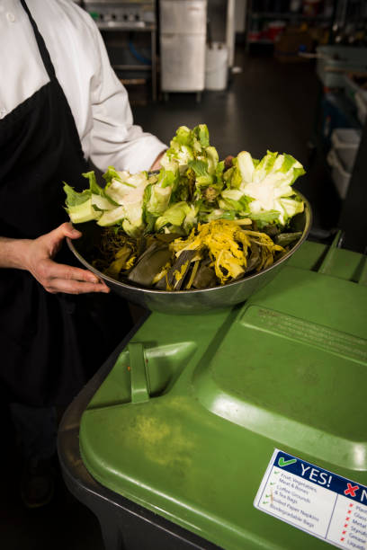 istock Woman server puts organic waste into bin for composting 2166059334