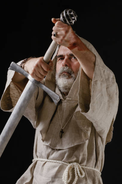 Medieval Viking barbarian warrior holding a sword in both hands poised ready to fight. Isolated 3D rendering.