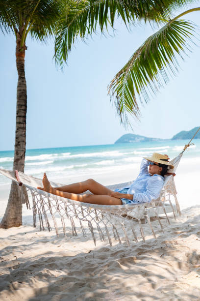istock Asian woman relaxing at the beach on a hammock 2166065311