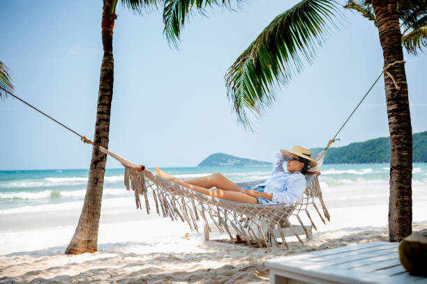 istock Asian traveler relaxing at the beach on a hammock 2166065312