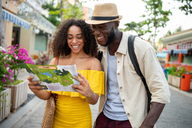 Happy tourists looking at a map while traveling