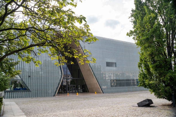 25.07.2024 Warsaw, Poland. The POLIN Museum of the History of Polish Jews showcases a modern architectural design with a unique, wavy entrance. Surrounded by trees, it stands on a cobblestone plaza, symbolizing the vibrant history of Polish Jews.