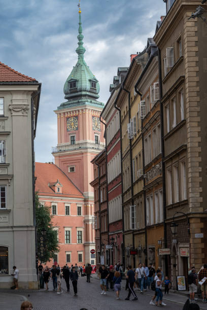 25.07.2024 Warsaw, Poland. The Royal Castle in Warsaw, framed by historic buildings, stands prominently amidst the bustling streets. This iconic landmark, with its distinctive tower and vibrant facade, symbolizes Poland's rich history and cultural heritage.
