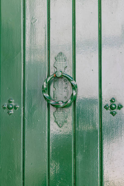 istock A ring shaped knocker on a green painted door. 2166079524