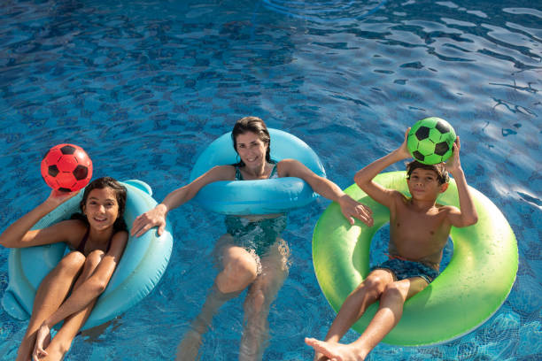istock Mother and children having fun in home pool 2166082848