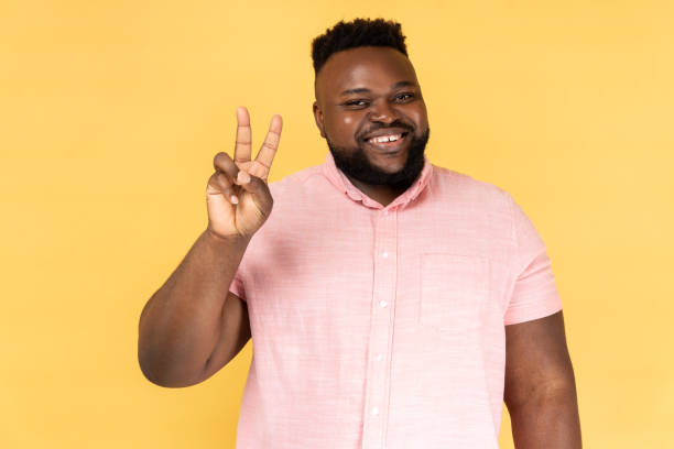 istock Man doing victory gesture and looking playfully to camera, showing peace, v sign with double fingers 2166084502
