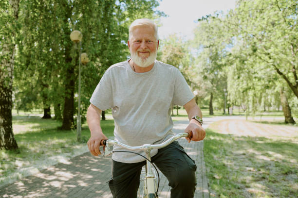 Brazilian senior riding an antique bike isolated on white background