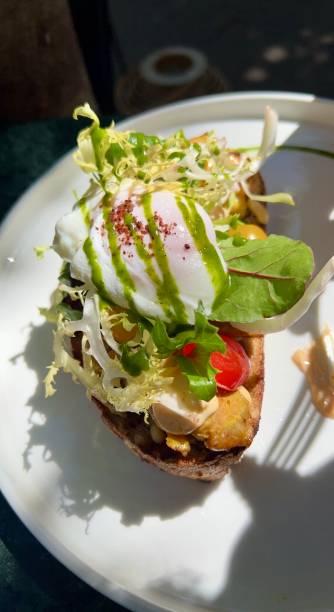 istock Brunch Delight: Poached Egg on a Bed of Tomatoes, Leaves, and Bacon 2166086184