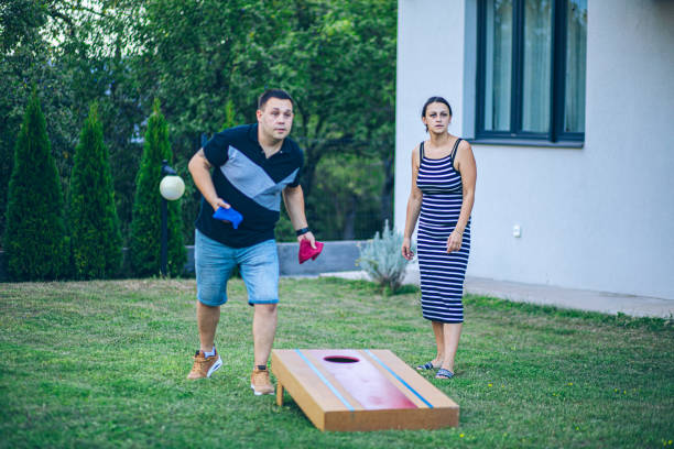 istock Couple playing bean bag toss in the backyard 2166086223